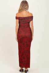 woman wearing a red floral off-the-shoulder maternity maxi dress, showcasing a fitted silhouette and ruched detailing
