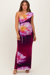 woman wearing a one-shoulder floral maternity dress in purple and pink tones with a fitted silhouette and maxi length