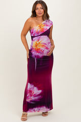 woman wearing a one-shoulder maternity maxi dress with floral print and holding her baby bump