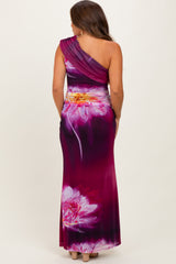 woman wearing a one-shoulder purple floral maternity gown with a fitted silhouette and a flowing skirt