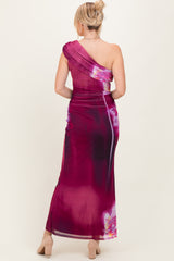 woman wearing a one-shoulder maxi dress with a purple and floral design, shown from the back