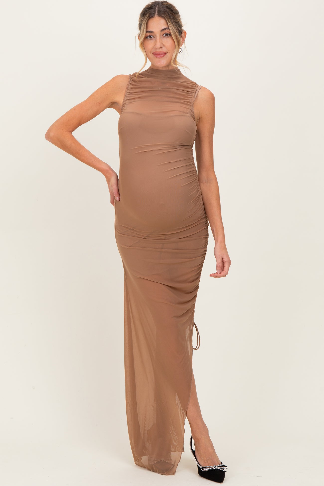 woman wearing a sheer brown maternity dress with ruched details and a gathered side, showcasing her baby bump