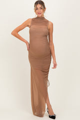 woman wearing a sheer brown maternity dress with ruched details and a gathered side, showcasing her baby bump