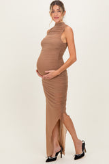 woman wearing a brown ruched maternity dress with a side slit and holding her baby bump