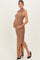 woman wearing a brown ruched maternity dress with a side slit and holding her baby bump