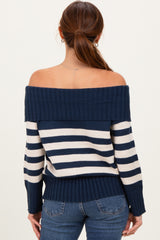 woman wearing a navy and cream striped off-the-shoulder sweater with ribbed detailing and fitted cuffs