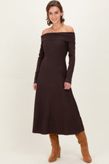 woman wearing a brown off-the-shoulder knit maxi dress and tan knee-high boots