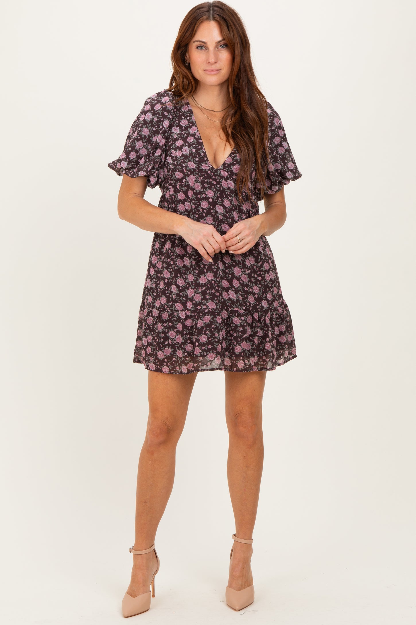 woman wearing a black floral short puff sleeve dress with a deep v-neckline and a flared skirt