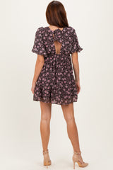 woman wearing a black floral short sleeve dress with a tie back detail and ruffle sleeves