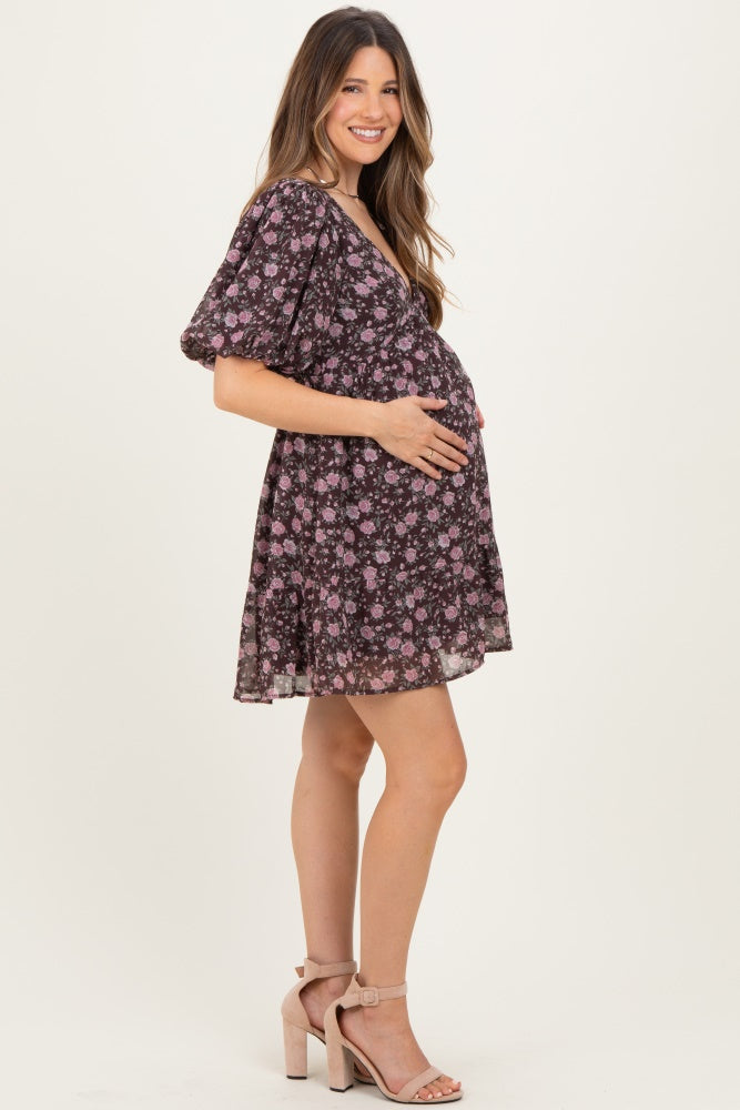 woman wearing a black floral maternity dress with short sleeves and a visible baby bump
