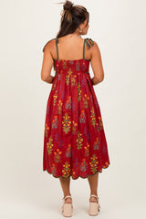woman wearing a red floral maternity dress with tie straps and a loose fit, showing a baby bump in the back view