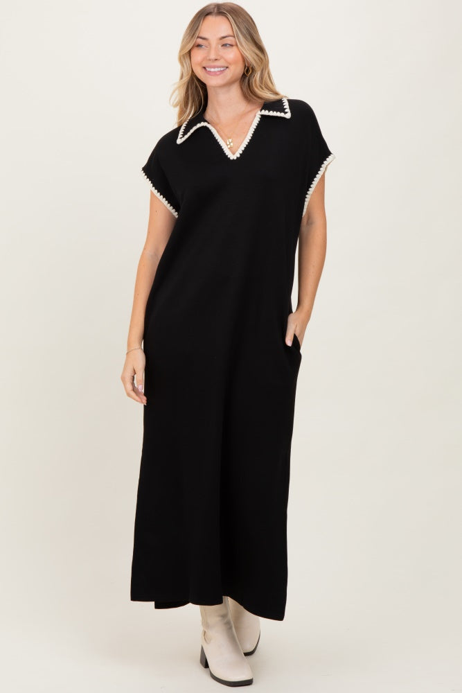 woman wearing a black maxi dress with a white collar and pockets, styled with cream ankle boots