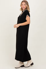 woman wearing a black maxi dress with short sleeves and white trim, paired with cream ankle boots