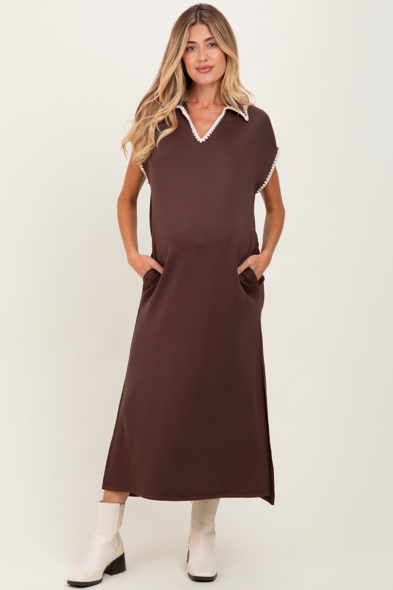 woman wearing a brown maternity maxi dress with a white collar and pockets