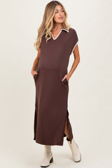 woman wearing a brown maternity maxi dress with a collar, side slits, and pockets, showing her baby bump