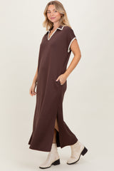 woman wearing a brown maxi dress with a collar and side slits, styled with white ankle boots