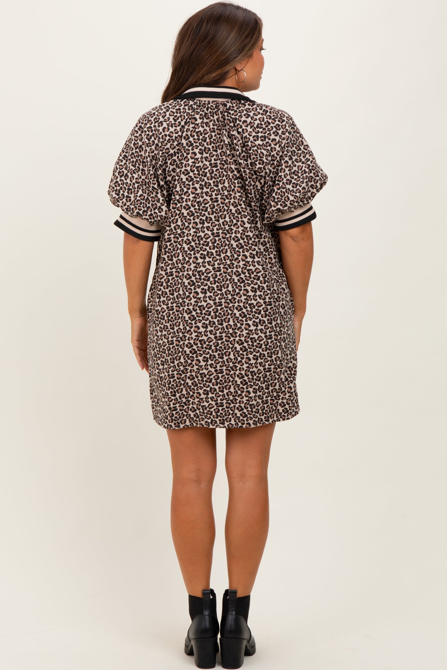woman wearing a brown leopard print maternity dress with short sleeves and a relaxed fit, showing the back view