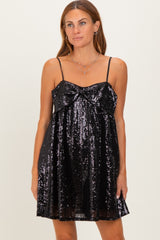 woman wearing a black sequin mini dress with a bow detail and spaghetti straps