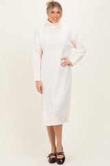 woman wearing a cream turtleneck sweater dress with long sleeves and side slits