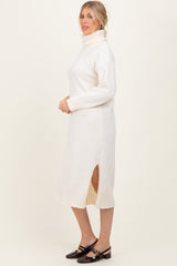 woman wearing a cream turtleneck sweater dress with side slits and ribbed detailing