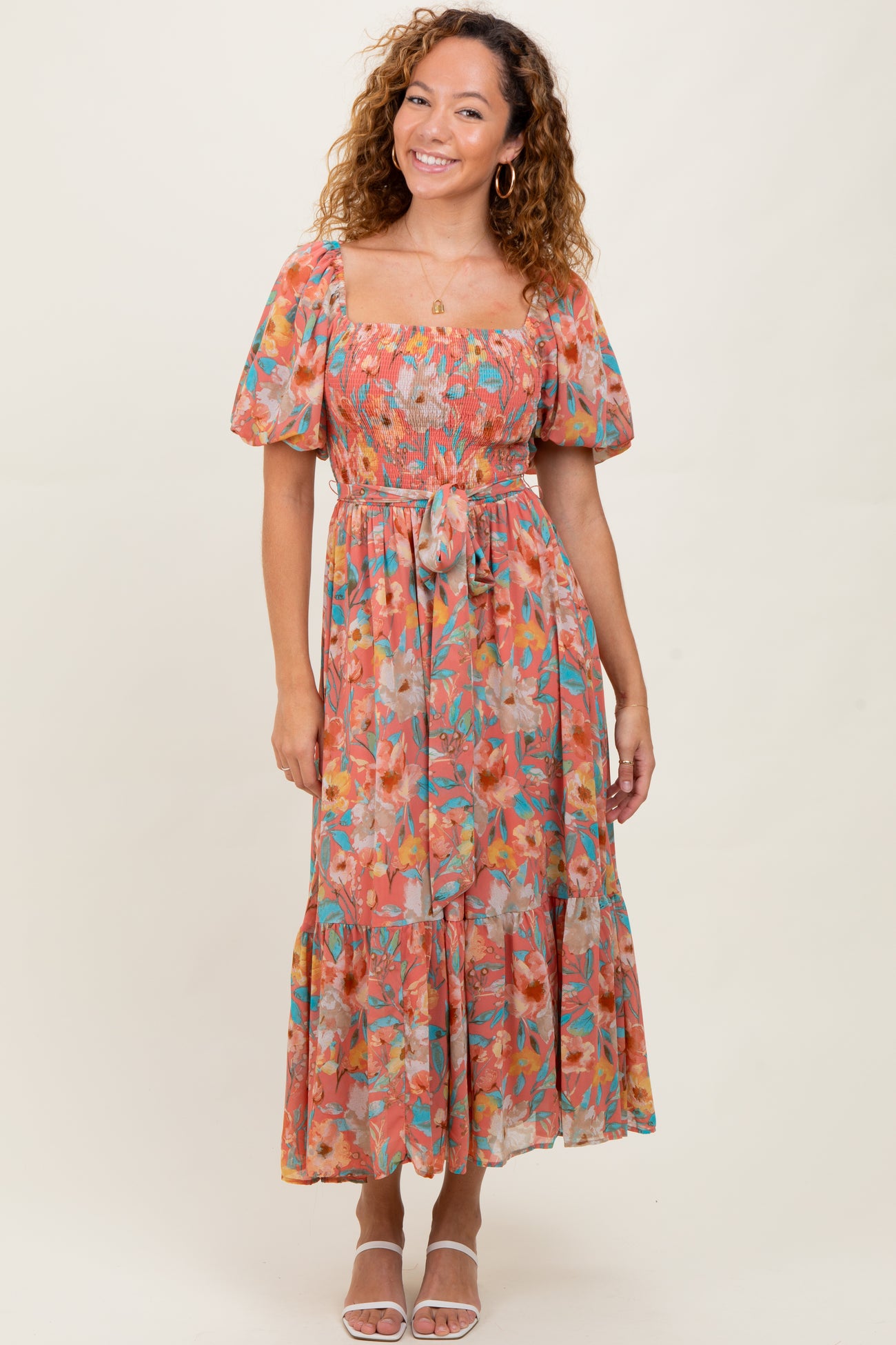 woman wearing a floral off-the-shoulder maxi dress with puff sleeves and a cinched waist