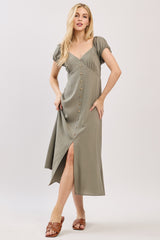 woman wearing a green button-up midi dress with short puff sleeves and a high slit