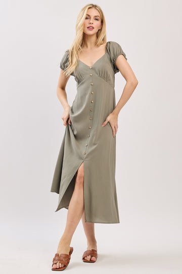 woman wearing a green button-up midi dress with short puff sleeves and a high slit