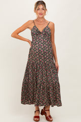 woman wearing a dark floral maternity maxi dress with a ruffled hem and thin straps, showcasing a baby bump