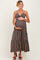 woman wearing a dark floral maternity maxi dress and holding her baby bump