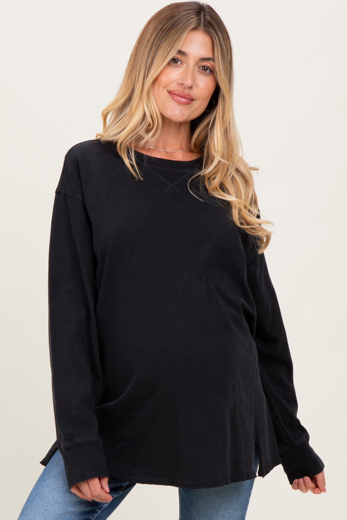woman wearing a black long sleeve maternity sweatshirt with a relaxed fit and visible baby bump