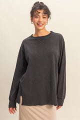 woman wearing a dark gray oversized long sleeve top with a relaxed fit and round neckline
