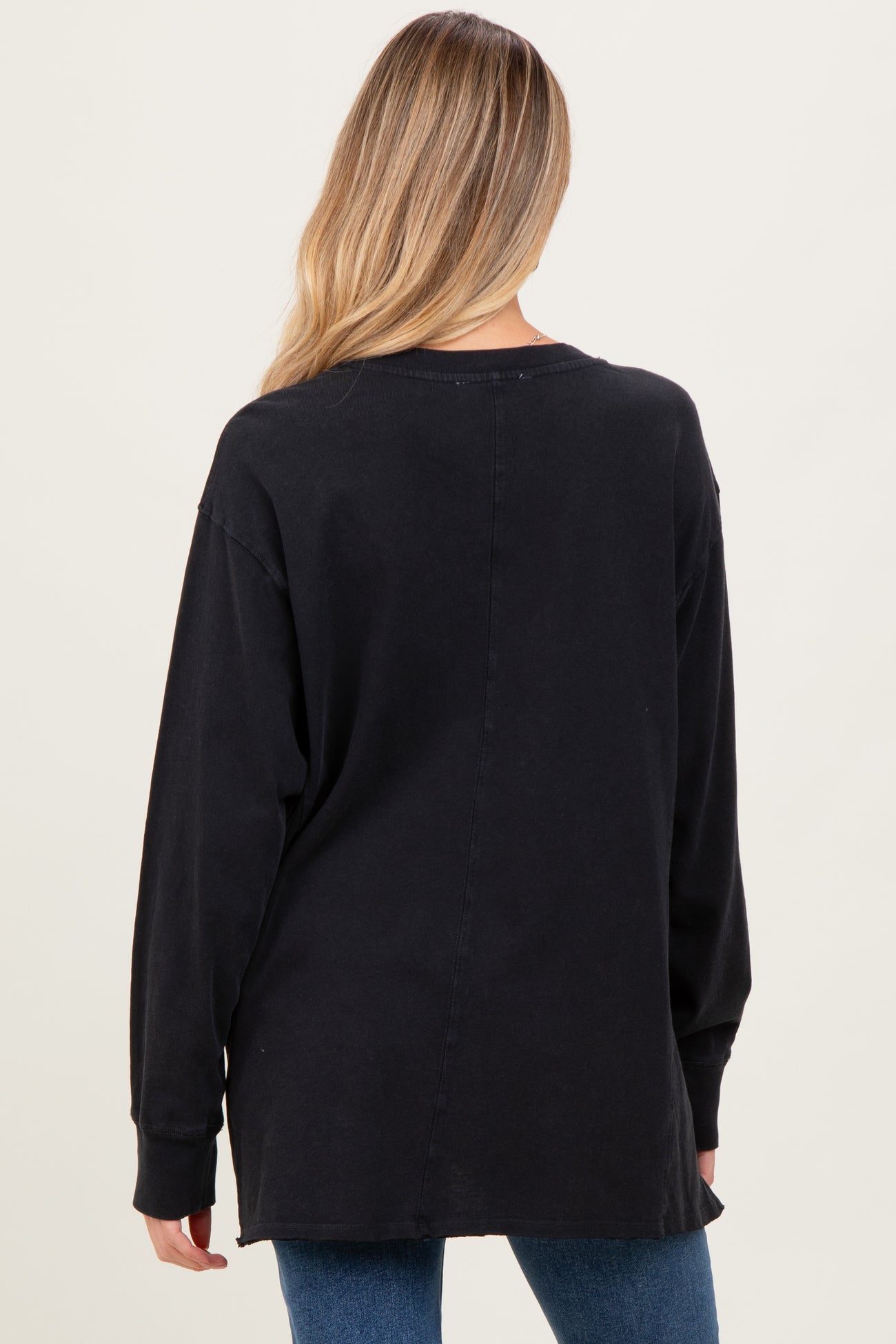 woman wearing a black long sleeve maternity top, back view, with a relaxed fit and side slits