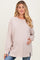 woman wearing a light taupe long sleeve maternity top and holding her baby bump