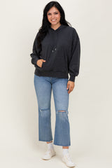 woman wearing a dark gray oversized hoodie paired with light blue flared jeans and white sneakers