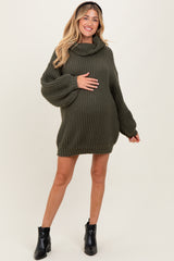 woman wearing a green ribbed maternity sweater dress with a cowl neck and a visible baby bump