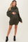 woman wearing a green ribbed maternity sweater dress with a cowl neck and a visible baby bump