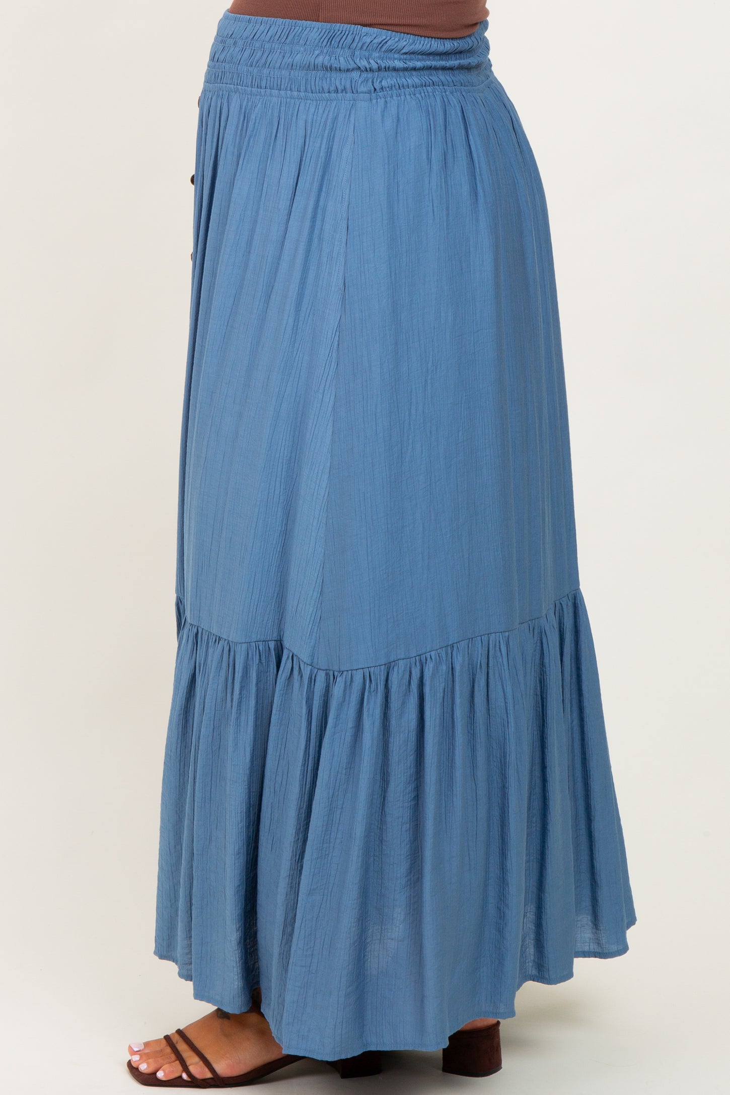 maternity wear flowy blue maxi skirt with a tiered design and smocked waist, model shown from the side