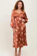 woman wearing an rust floral long sleeve midi dress with puff sleeves and a fitted bodice