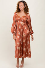 woman wearing a rust floral midi dress with puff sleeves and a square neckline
