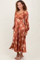 woman wearing a rust floral patterned midi dress with puffy sleeves and a relaxed fit