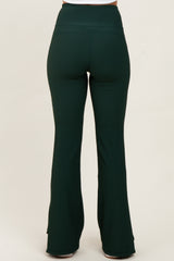 woman wearing dark green ribbed flared pants viewed from the back