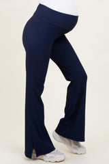 woman wearing navy maternity active pants with a flared leg and side slits, showing a visible baby bump