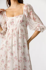 woman wearing a floral print long sleeve maxi dress with a square neckline and puff sleeves