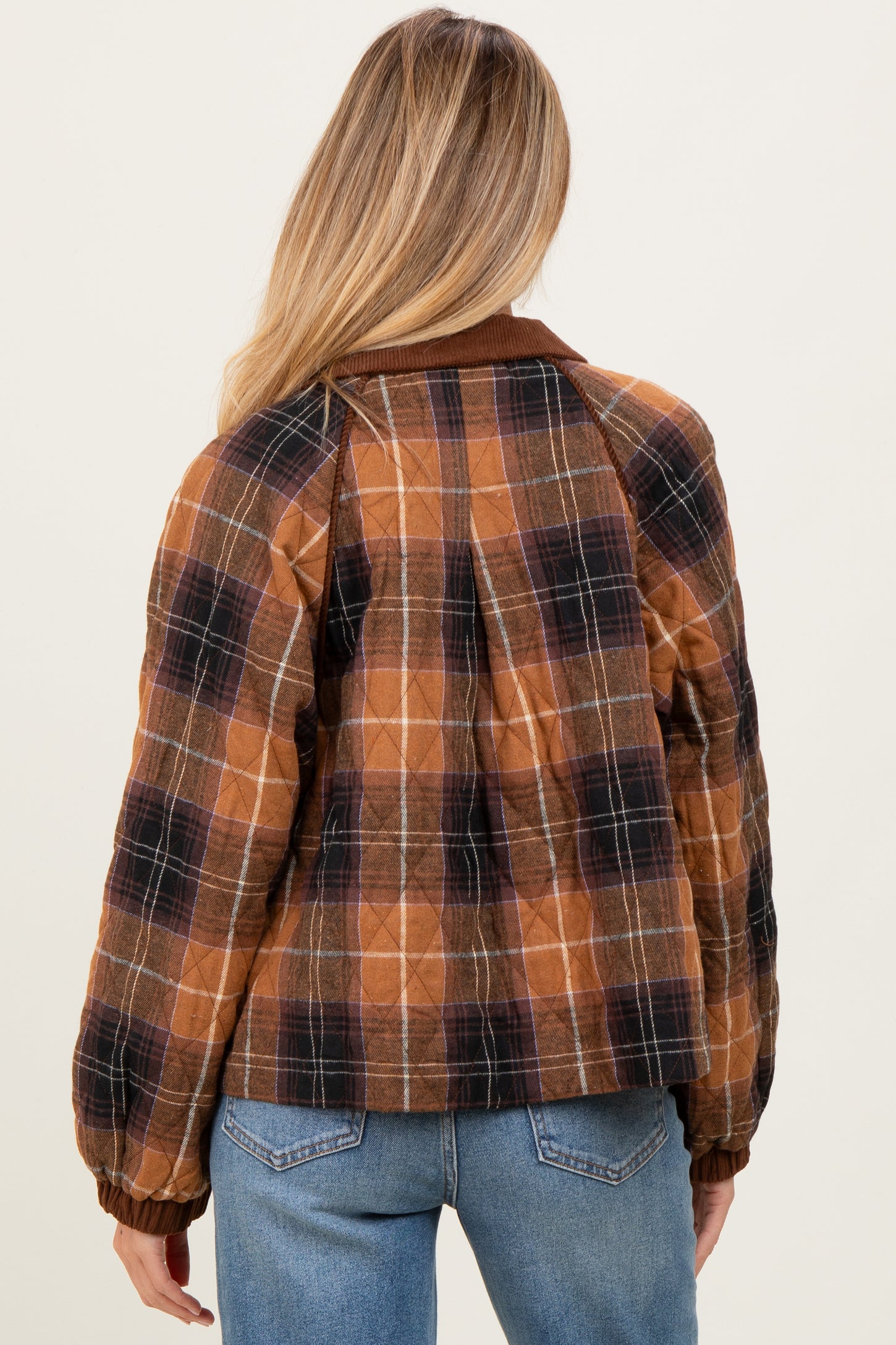 woman wearing a brown plaid maternity bomber jacket with puffed sleeves and a relaxed fit