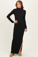 woman wearing a black long sleeve turtleneck maxi dress with a side slit and standing in a relaxed pose