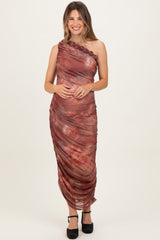 woman wearing a one-shoulder burgundy maternity dress with floral details and a fitted silhouette, showcasing her baby bump