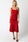 woman wearing a red ruched midi dress with a fitted bodice and flared hem
