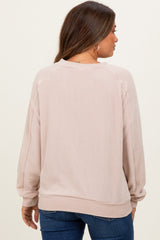 woman wearing a light pink maternity sweatshirt with ribbed texture, seen from the back