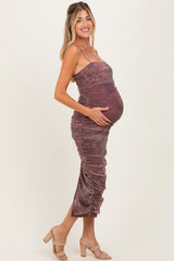 woman wearing a maroon ruched maternity dress, highlighting her baby bump, standing in a side profile pose