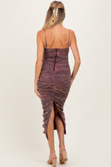 woman wearing a burgundy maternity dress with ruched detailing and a back slit